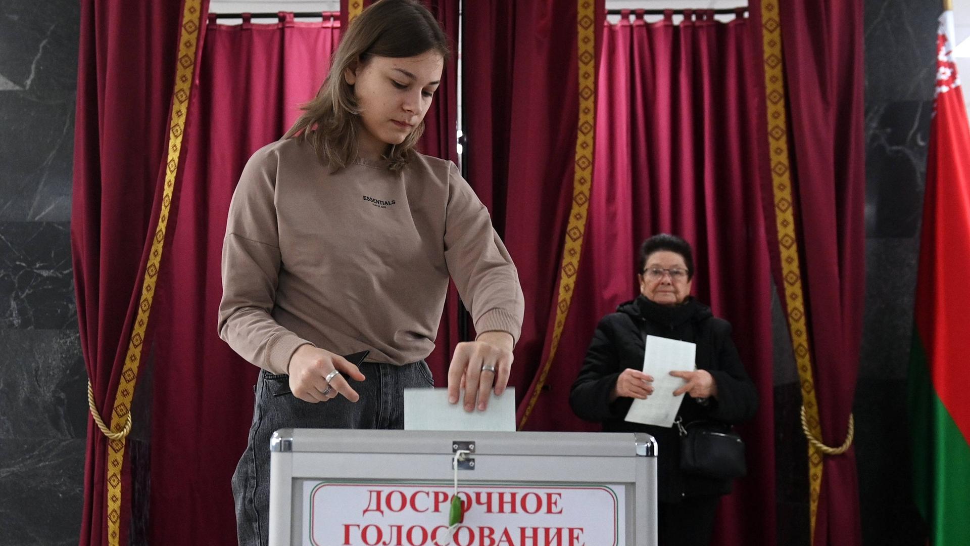 Eine Frau gibt während der vorgezogenen Stimmabgabe am 21. Januar 2025 ihren Stimmzettel für die weißrussischen Präsidentschaftswahlen in einem Wahllokal in Minsk, Weißrussland, ab.