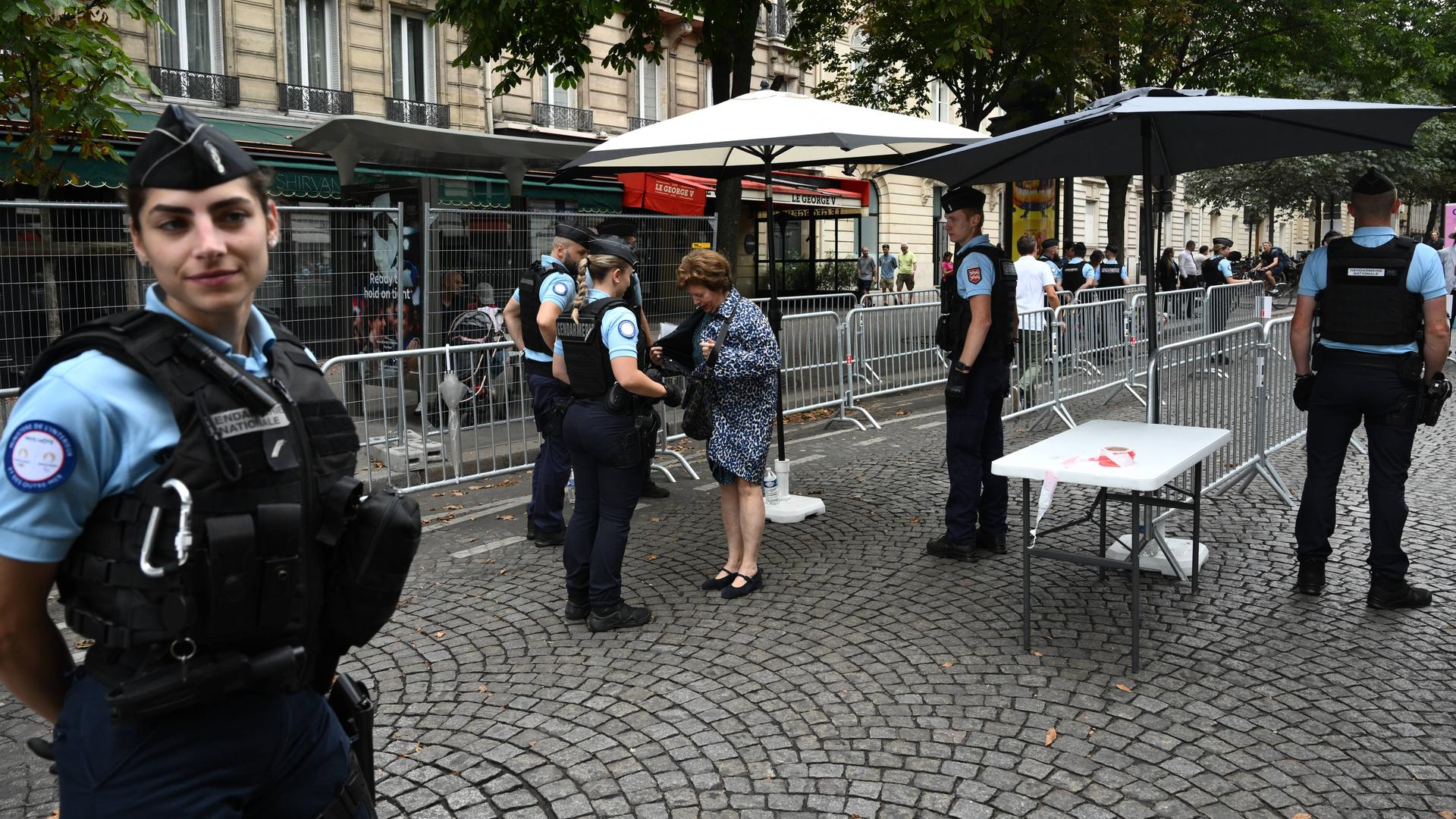 Eine Frau wird an einer Absperrung in Paris kontrolliert.