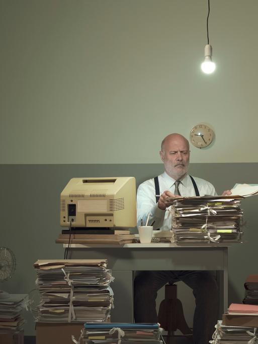 Symbolbild: Frustrierter Geschäftsmann im Vintage-Stil, der in einem heruntergekommenen Büro arbeitet und mit Papierkram überfordert ist.