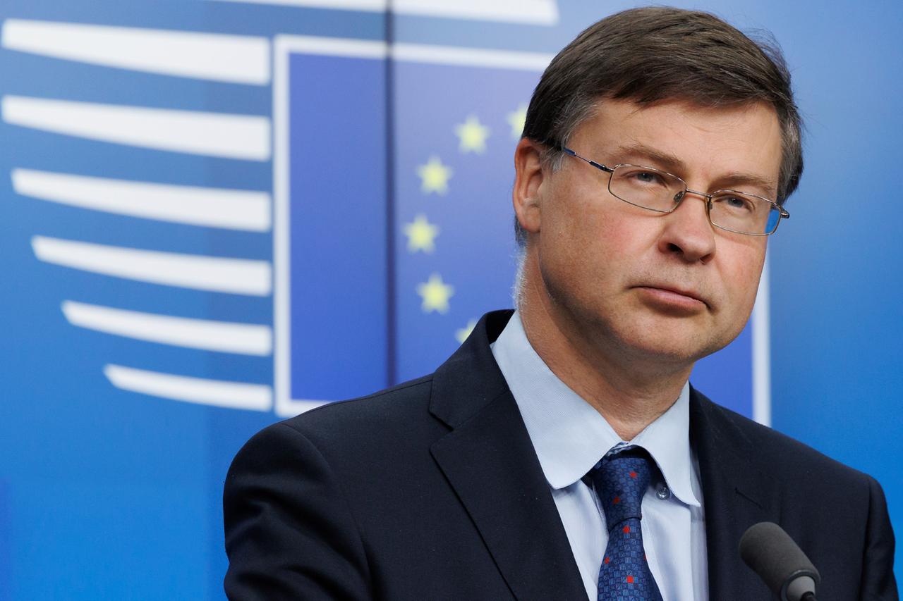 Valdis Dombrovskis im Porträt vor einer Wand mit einer EU-Flagge