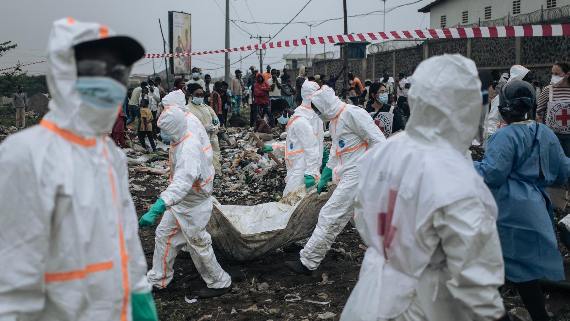 Mitglieder des kongolesischen Roten Kreuzes tragen Oper aus einem Camp.