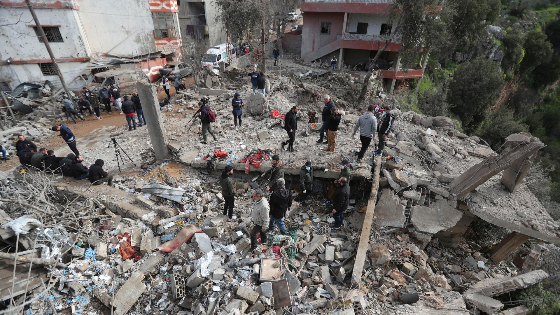 Libanon, Hebbariye: Menschen stehen neben und auf den Trümmern eines Sanitätszentrums, das durch einen israelischen Luftangriff am frühen Mittwoch im Dorf Hebbariye im Südlibanon zerstört wurde.