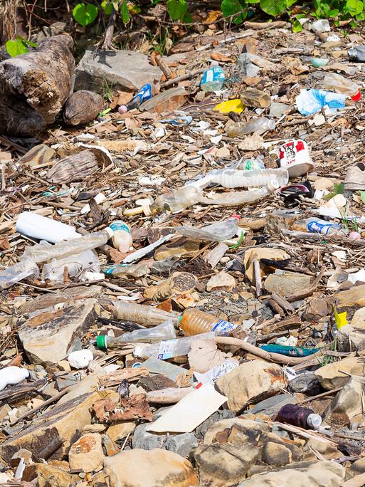 KOTA KINABALU, SABAH, MALAYSIA - 06. JANUAR 2022: Müll und Plastikflaschen an einem Strand links in Tanjung Aru Beach xkwx Meer, Tourismus, Flasche, Problem, Müll, Ökologie, Küste, Strand, Umwelt, Entsorgung, global, Abfall, Müll, Industrie, Natur.