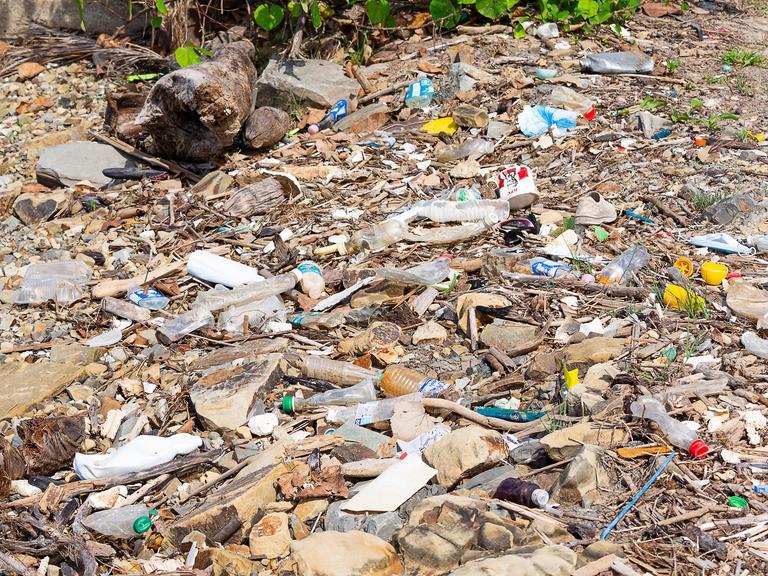 KOTA KINABALU, SABAH, MALAYSIA - 06. JANUAR 2022: Müll und Plastikflaschen an einem Strand links in Tanjung Aru Beach xkwx Meer, Tourismus, Flasche, Problem, Müll, Ökologie, Küste, Strand, Umwelt, Entsorgung, global, Abfall, Müll, Industrie, Natur.