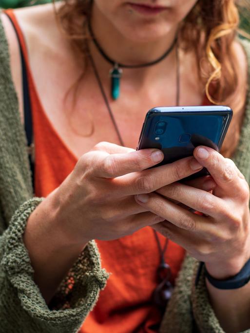 Eine Frau hat ein Smartphone in der Hand