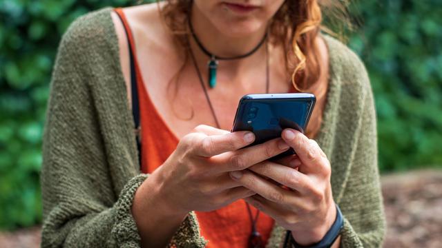 Eine Frau hat ein Smartphone in der Hand