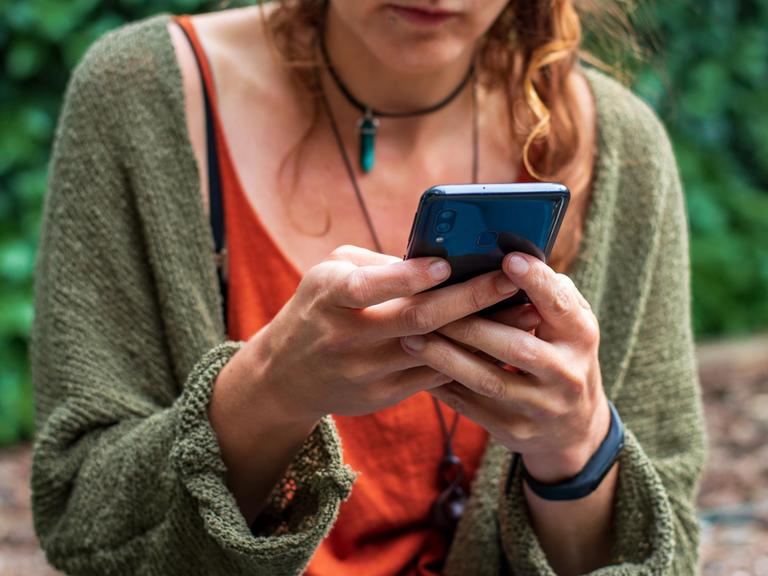 Eine Frau hat ein Smartphone in der Hand