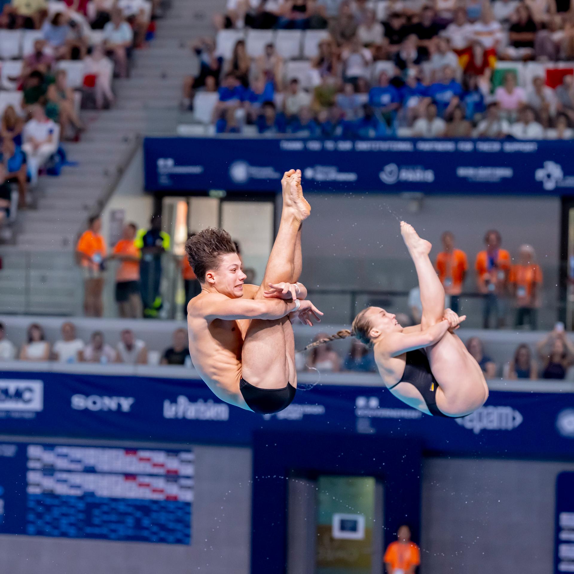 Lena Hentschel und Luis Carlo Avila Sanchez sichern sich Bronze. Sie fliegen nach dem Sprung vom Drei-Meter-Brett durch die Luft.
