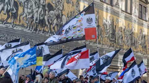 Teilnehmer einer Demonstration ziehen mit Flaggen vom Königreich Preußen (schwarz-weiß-schwarz mit Adler) über die Dresdener Augustusstraße am Fürstenzug vorbei.