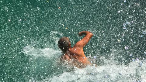 Jean geht Schwimmen und kommt nicht wieder. Zu sehen: Männerbeine schauen aus dem Meer heraus. 