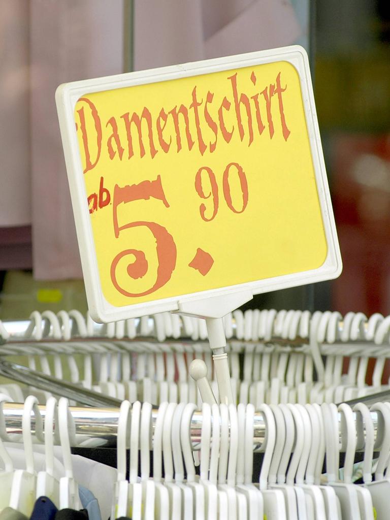 Damentschirt - Preisschild auf einer Kleiderstange.