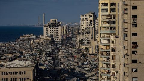 Ein Blick über einige Hochhäuser in Gaza-Stadt, dazwischen sind Zeltunterkünfte zu sehen. Viele der Gebäude sind zerstört. 