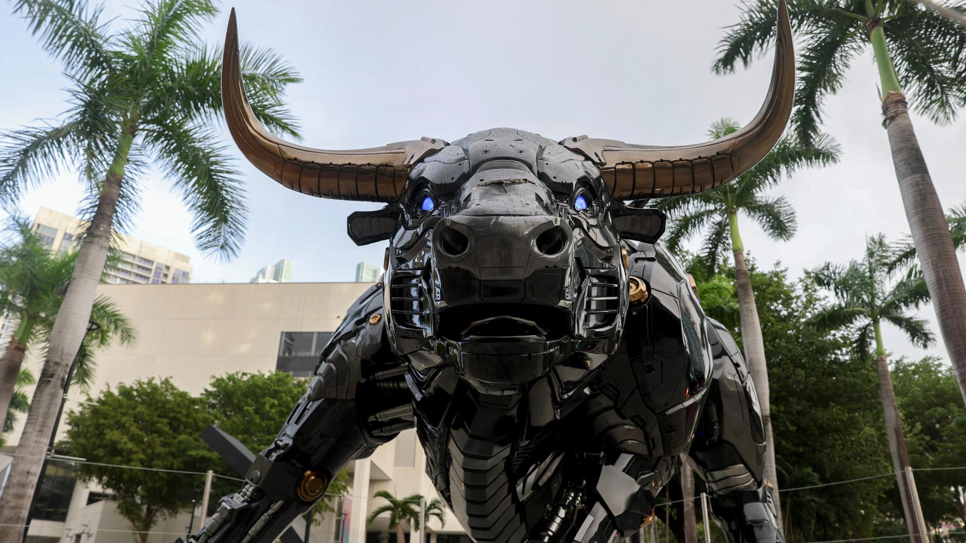 Eine Statue, die aussieht wie der Wall Street-Bulle, nur in einer Roboterversion mit blau leuchtenden Augen.