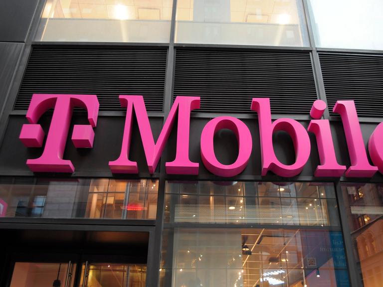 Ein T-Mobile Shop in Manhattan. Der Firmenname in großen pinken Lettern an der Glasfassade
