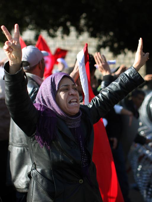 Januar 2011 in Tunis / Tunesien: Eine Demonstrantin mit Kopftuch fordert lautstark Soldaten auf, sie durch die Stacheldrahtbarrikade vor dem Büro des tunesischen Premierministers zu lassen. 