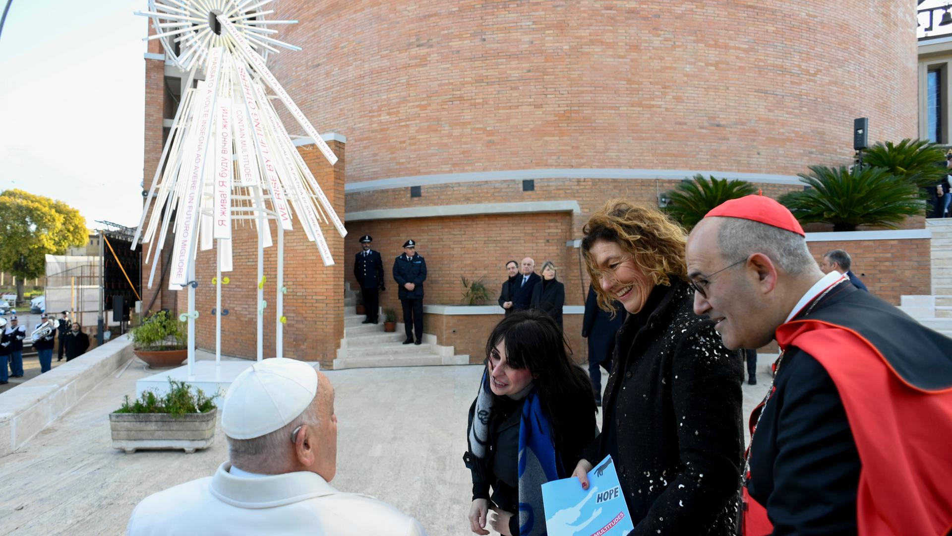 Papst Frankziskus (l.) vor der Kirche des Gefängnisses Rebibbia am Stadtrand von Rom bei der Einweihnung einer von Gefängnisinsassen und der Künstlerin Marinella Senatore (2.v.l.) geschaffenen skulpturale Lichtinstallation. Papst Frankziskus (l.) vor der Kirche des Gefängnisses Rebibbia am Stadtrand von Rom bei der Einweihnung einer von Gefängnisinsassen und der Künstlerin Marinella Senatore (2.v.l.) geschaffenen skulpturale Lichtinstallation.