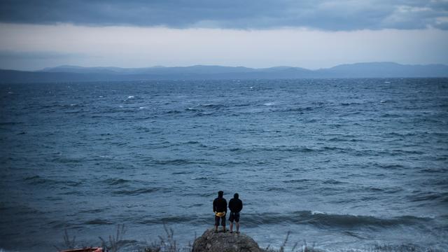 Zwei Personen schauen auf der griechischen Insel Lesbos aufs Mittelmeer in Richtung Türkei.