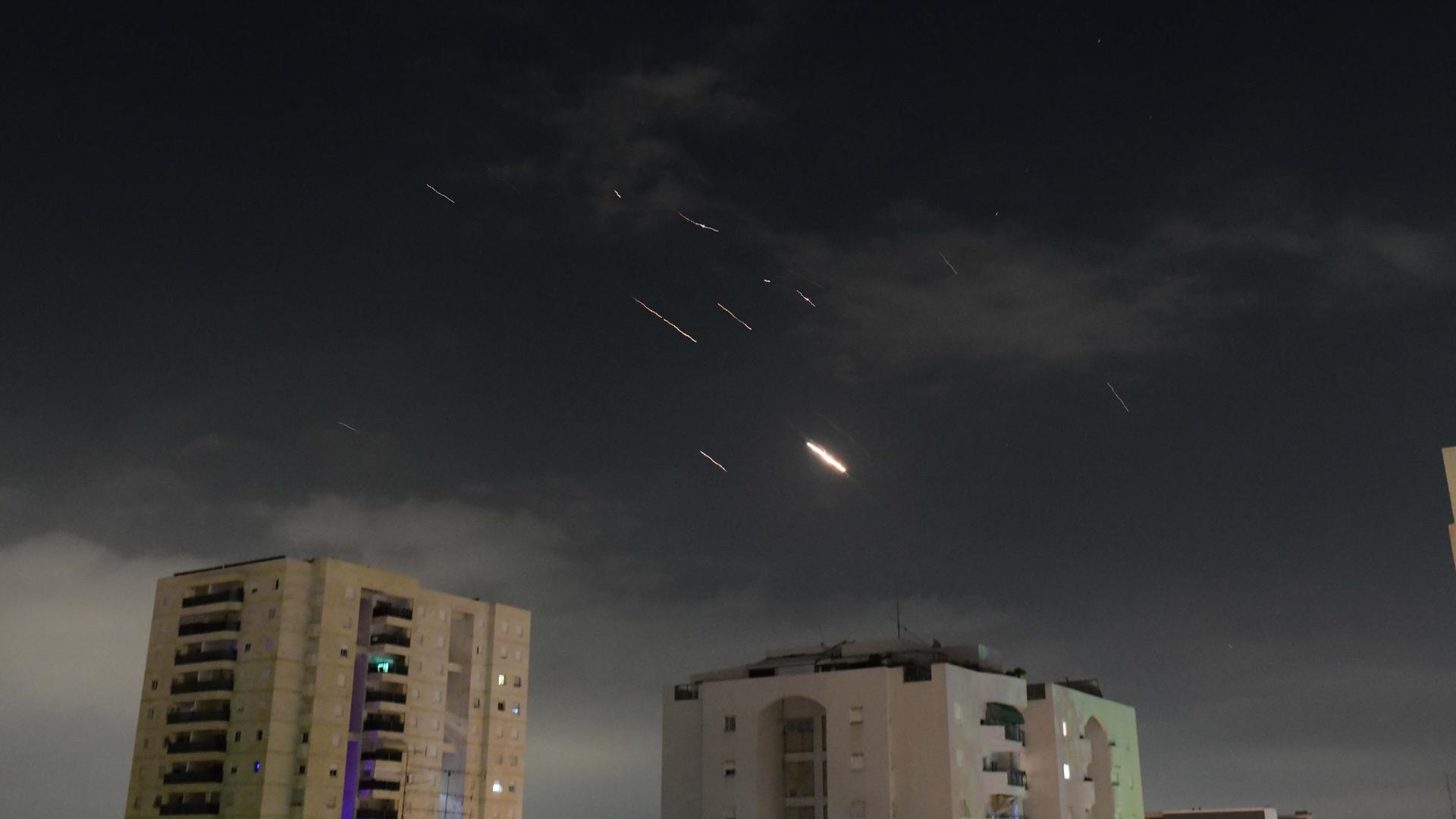 Flammen von Explosionen sind am Himmel über Tel Aviv zu sehen, während Israels Raketenabwehrsystem Raketen und Drohnen aus dem Iran abfängt.