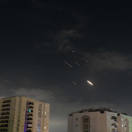 Flammen von Explosionen sind am Himmel über Tel Aviv zu sehen, während Israels Raketenabwehrsystem Raketen und Drohnen aus dem Iran abfängt.