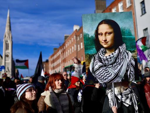 Pro-palästinensische Demonstranten gehen auf der O’Connell Street in Dublin im November 2025. Auf einem Protestschild trägt die Mona Lisa ein schwarz-weisses Palästinensertuch Pro-palästinensische Demonstranten gehen auf der O’Connell Street in Dublin im November 2025. Auf einem Protestschild trägt die Mona Lisa ein schwarz-weisses Palästinensertuch