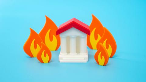 Illustration: Ein Regierungsgebäude ist von einem Feuer umgeben, Symbol für eine politische Krise. 