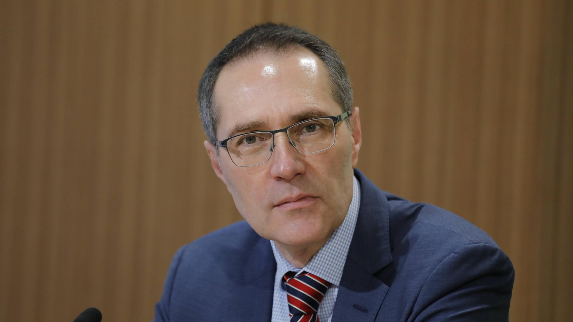 Müller-Kraenner mit brille und dunkelblauem Jackett sitzt vor einer braunen Wand und blickt in die Kamera. Müller-Kraenner mit brille und dunkelblauem Jackett sitzt vor einer braunen Wand und blickt in die Kamera.