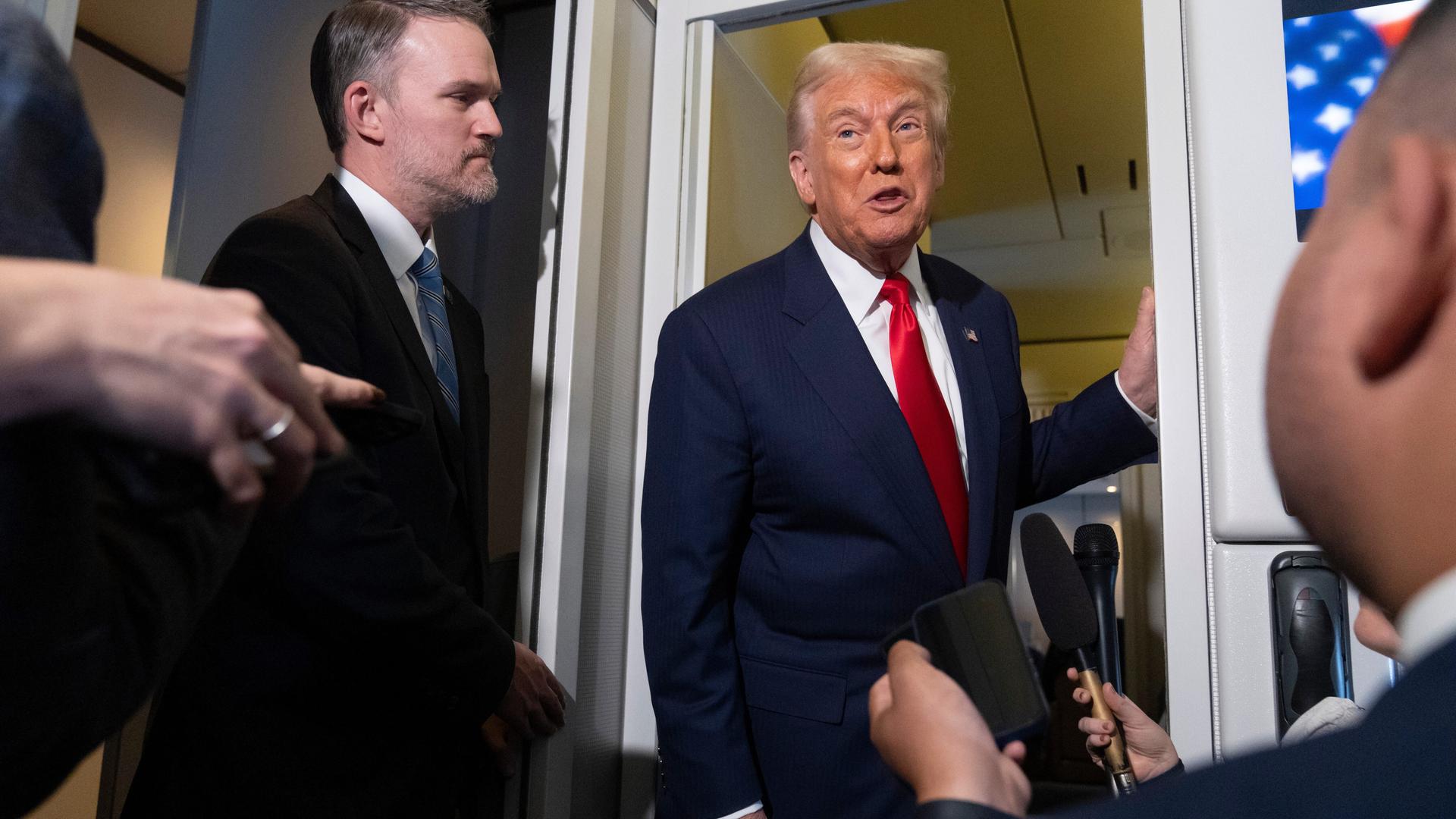 US-Präsident Donald Trump lehnt an der Tür der Regierungsmaschine Airforce One im Gespräch mit Reportern am 30.10.2025 US-Präsident Donald Trump lehnt an der Tür der Regierungsmaschine Airforce One im Gespräch mit Reportern am 30.10.2025