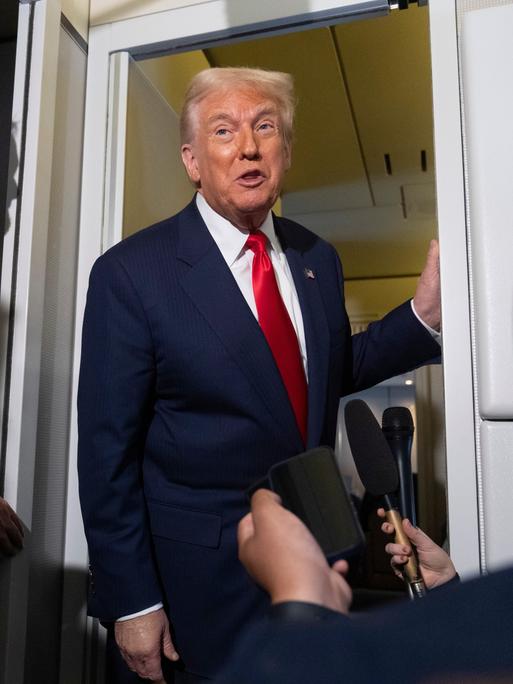 US-Präsident Donald Trump lehnt an der Tür der Regierungsmaschine Airforce One im Gespräch mit Reportern am 30.10.2025 US-Präsident Donald Trump lehnt an der Tür der Regierungsmaschine Airforce One im Gespräch mit Reportern am 30.10.2025