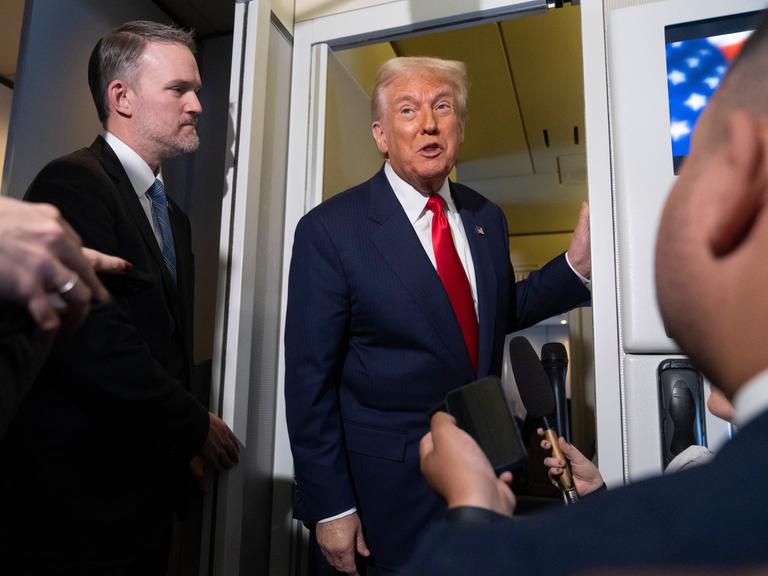 US-Präsident Donald Trump lehnt an der Tür der Regierungsmaschine Airforce One im Gespräch mit Reportern am 30.10.2025 US-Präsident Donald Trump lehnt an der Tür der Regierungsmaschine Airforce One im Gespräch mit Reportern am 30.10.2025