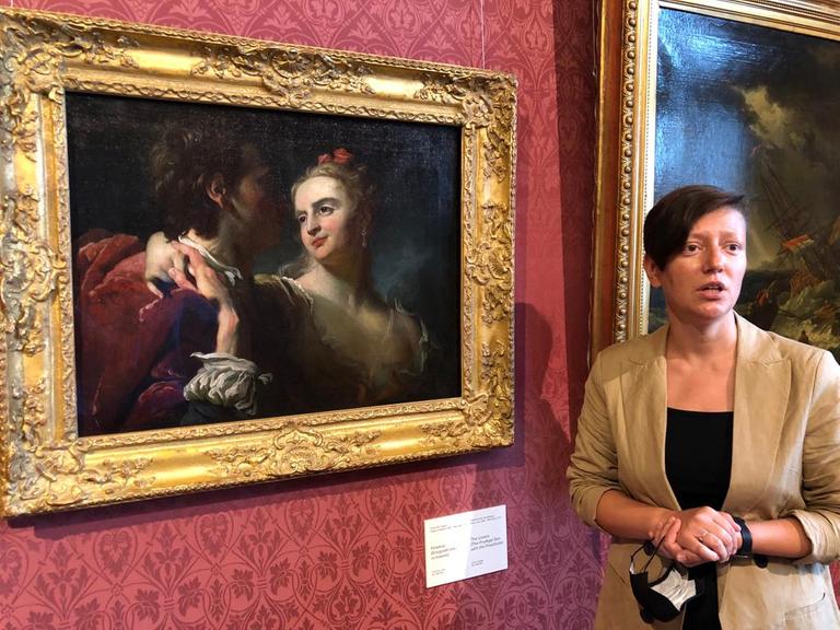Kateryna Tschujewa steht im Chanenko-Museum vor einem restituierten Gemälde.