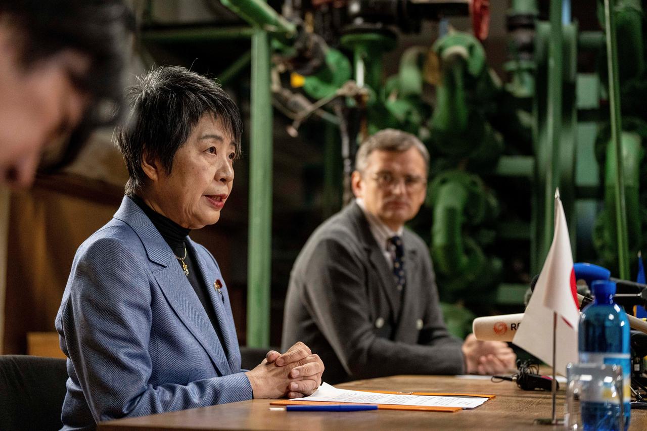 Japans Außenministerin Kamikawa und der ukrainische Außenminister Kuleba sitzen bei einer Pressekonferenz in einem Bunker in Kiew nebeneinander.