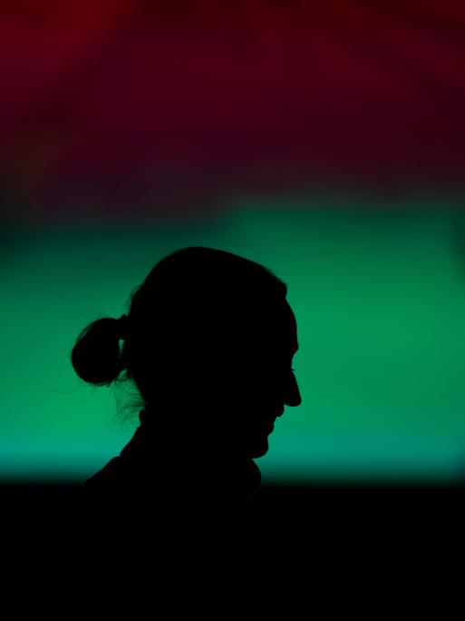 Ein Schatten vor grünem Hintergrund zeigt das Profil von Alice Weidel