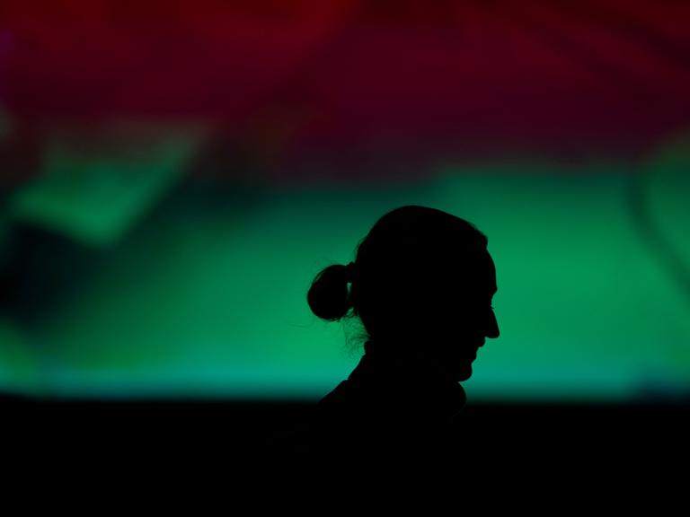 Ein Schatten vor grünem Hintergrund zeigt das Profil von Alice Weidel