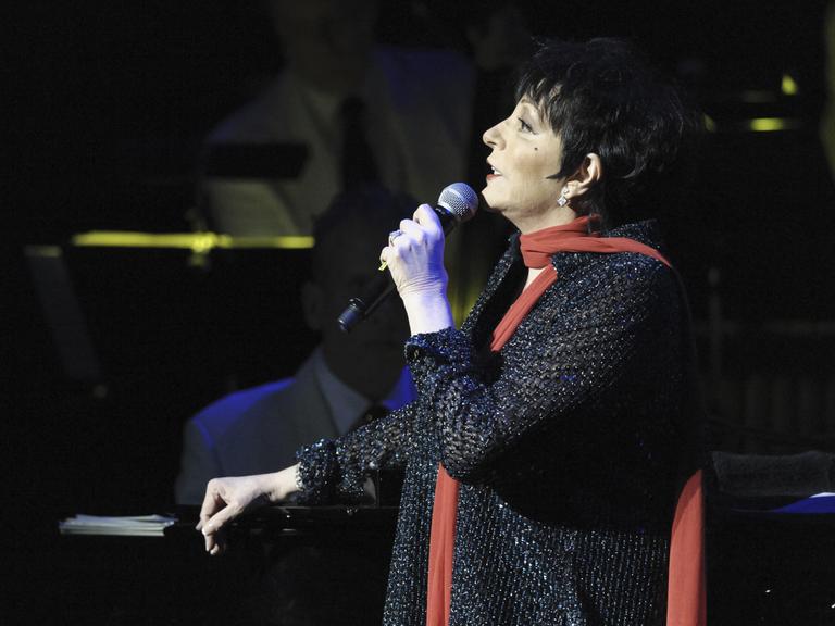 Liza Minnelli im Profil wie sie in ein Mikrofon singt