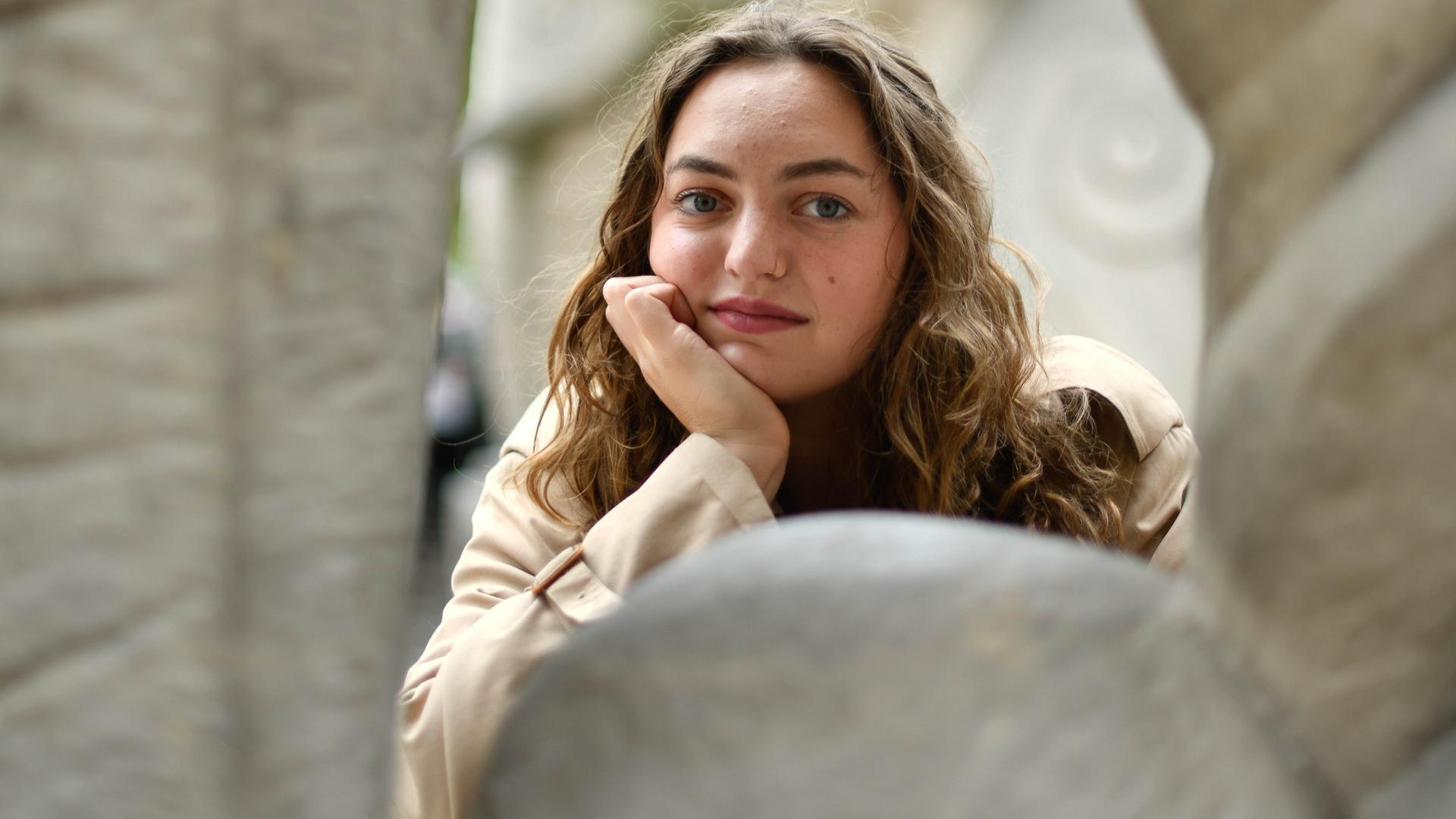 Schriftstellerin Dana Vowinckel stützt ihren Kopf auf die Hand auf und blickt direkt in die Kamera