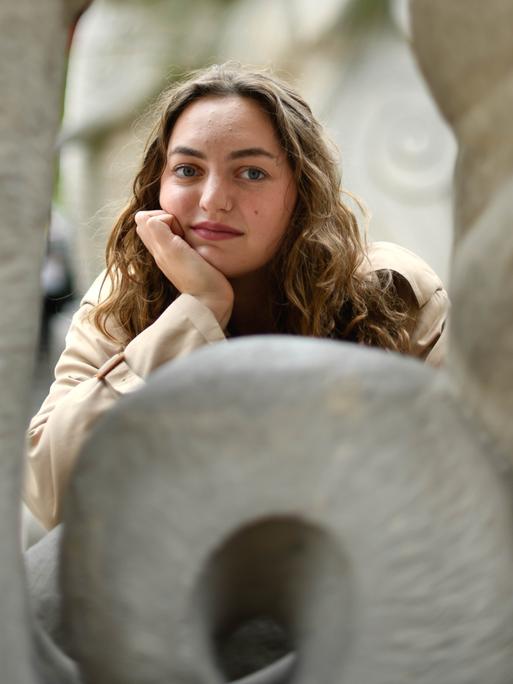 Schriftstellerin Dana Vowinckel stützt ihren Kopf auf die Hand auf und blickt direkt in die Kamera Schriftstellerin Dana Vowinckel stützt ihren Kopf auf die Hand auf und blickt direkt in die Kamera
