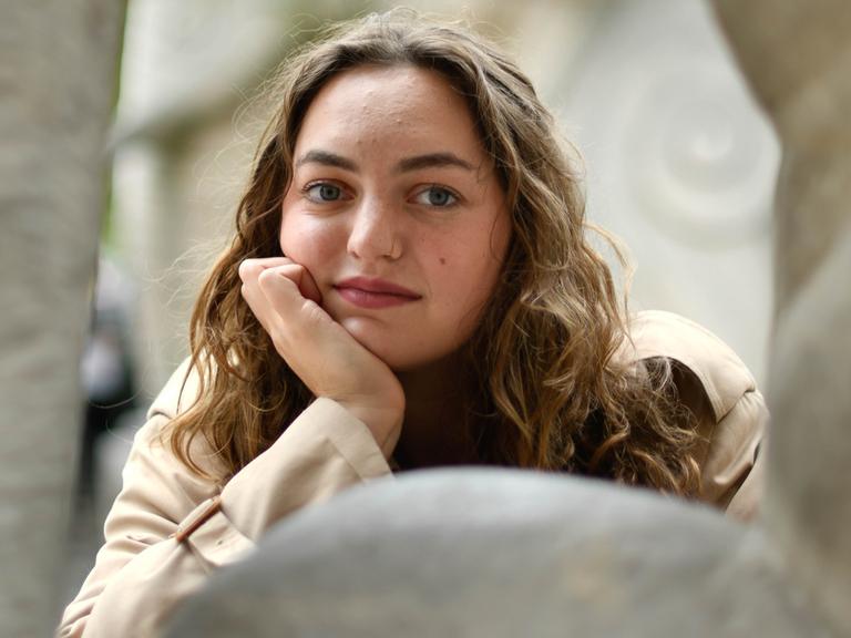 Schriftstellerin Dana Vowinckel stützt ihren Kopf auf die Hand auf und blickt direkt in die Kamera Schriftstellerin Dana Vowinckel stützt ihren Kopf auf die Hand auf und blickt direkt in die Kamera