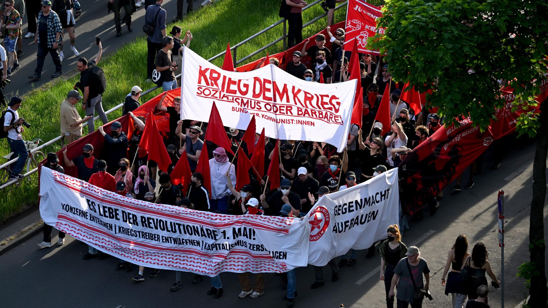 Teilnehmerinnen und Teilnehmer der "Revolutionären 1. Mai-Demonstration" halten ein Banner mit dem Schriftzug "Krieg dem Krieg" hoch. 
