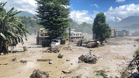 Zerstörte Autos in einer von Schlamm überfluteten Straße in Kathmandu, Nepal