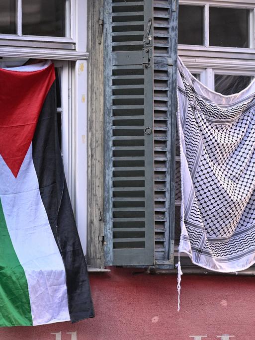 Palästinaflagge und Palästinensertuch in zwei Fenstern am Tübinger Holzmarkt