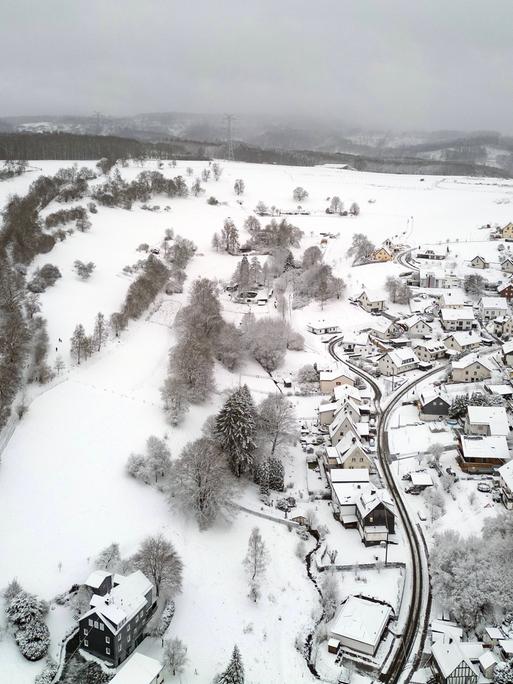 Luftaufnahme. Winter im Siegerland. Blick über den verschneiten Ort Siegen-Oberschelden. Es hat sehr viel geschneit. 