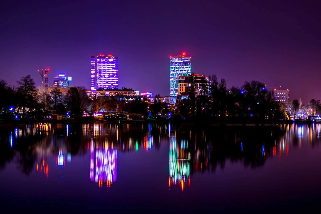 Die Skyline von Bukarest bei Nacht, in lila Farben getaucht.