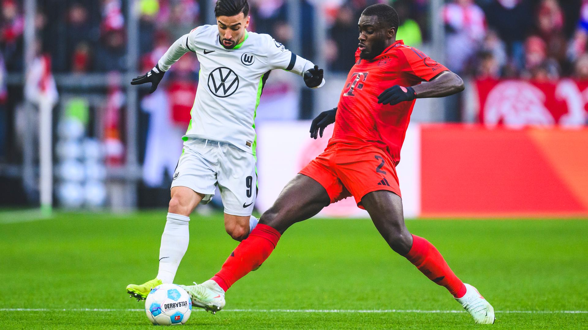 Wolfsburgs Mohamed Amoura (l) in Aktion gegen Münchens Dayot Upamecano 