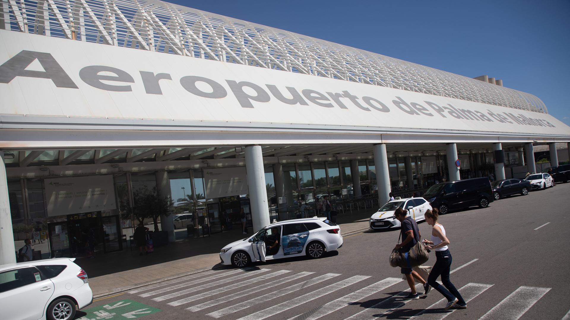 Menschen gehen am Flughafen von Palma de Mallorca.