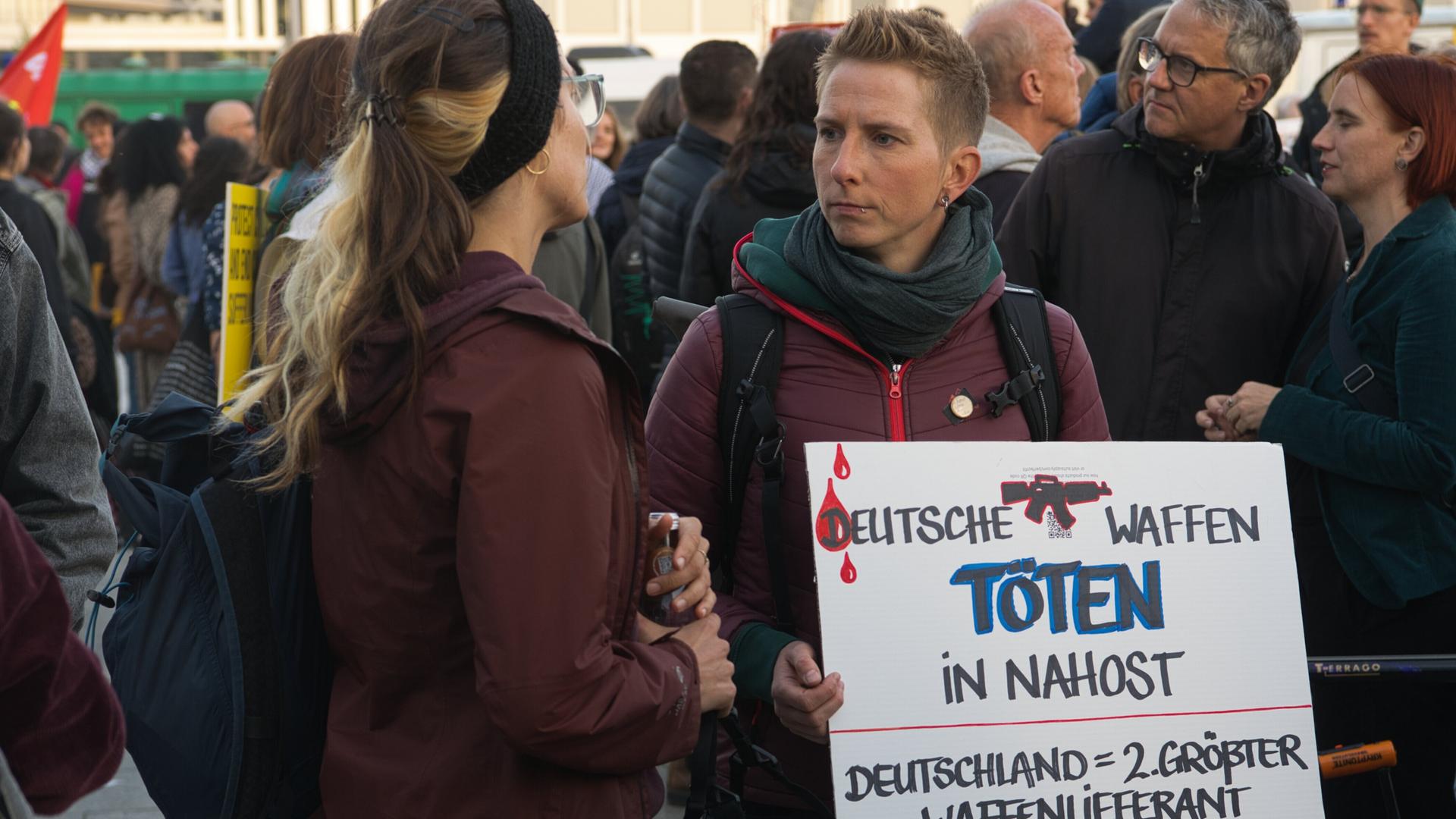 Person hält bei Demo "Für einen gerechten Frieden in Palästina und Israel" ein Schild mit der Aufschrift "DEUTSCHE WAFFEN TÖTEN IN NAHOST" hoch