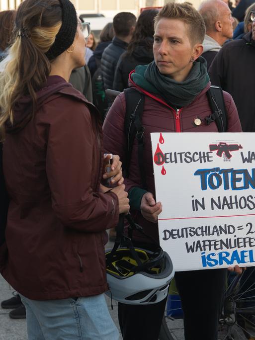 Person hält bei Demo "Für einen gerechten Frieden in Palästina und Israel" ein Schild mit der Aufschrift "DEUTSCHE WAFFEN TÖTEN IN NAHOST" hoch