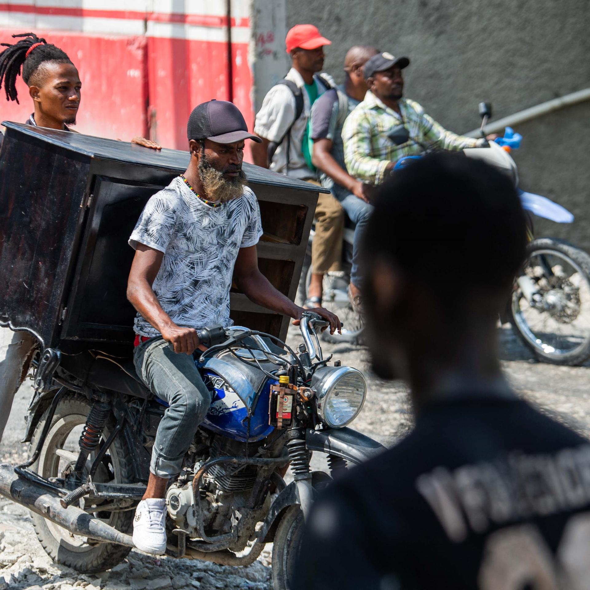 Menschen in Port-au-Prince flüchten auf Motorrädern, die voll bepackt sind mit ihren Habseligkeiten.