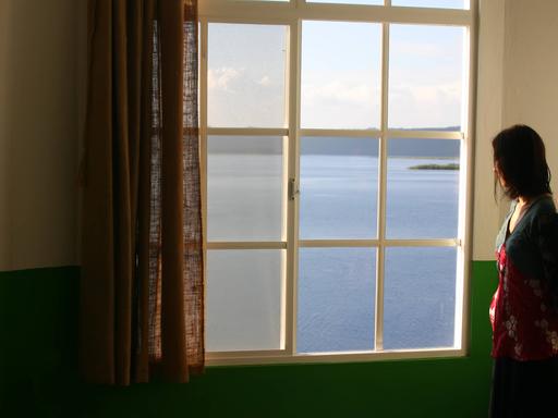 Eine Frau steht allein am Fenster. Eine Frau steht allein am Fenster.