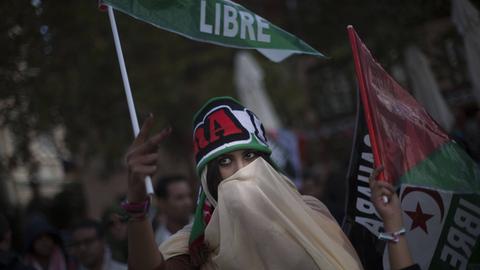 Eine Frau mit Schleier vor dem Gesicht demonstriert für die Unabhängigkeit der Westsahara und gegen die Besetzung durch Marokko. 