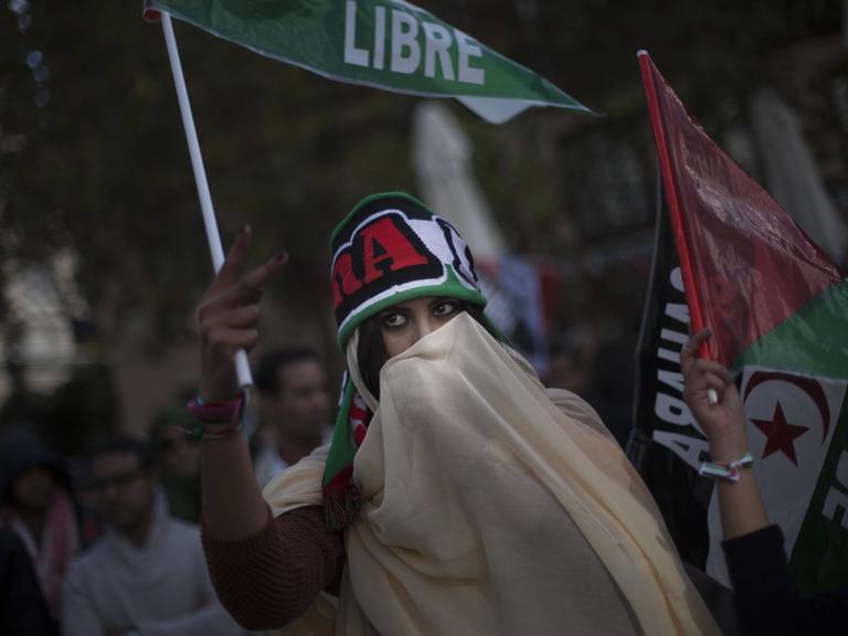 Eine Frau mit Schleier vor dem Gesicht demonstriert für die Unabhängigkeit der Westsahara und gegen die Besetzung durch Marokko. 
